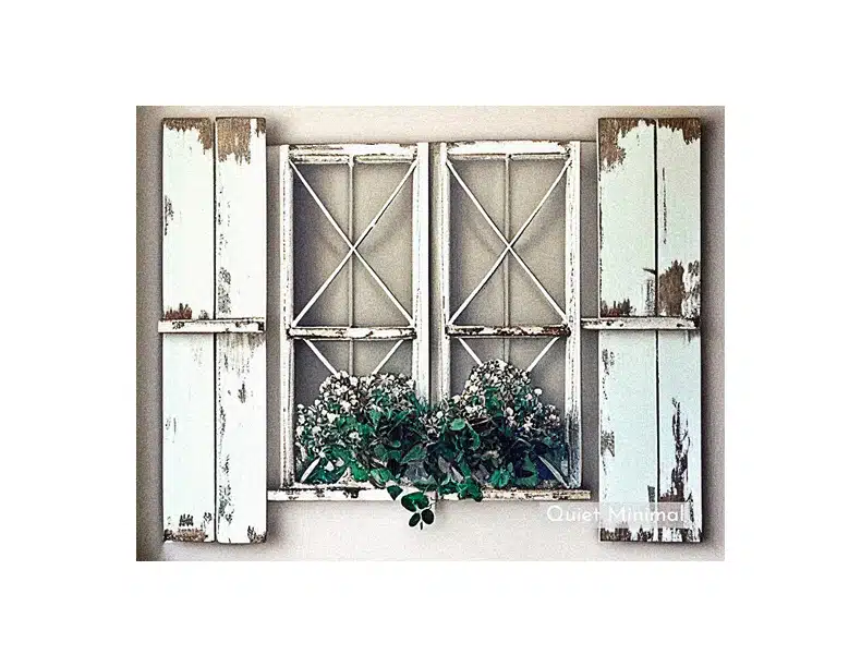Transform old windows into home decor with white shutters and a potted plant.