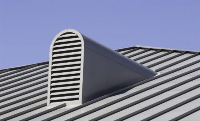 Dormer vent with metal grate on rooftop for effective attic ventilation