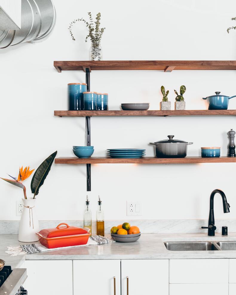 Floating shelves in a modern kitchen design, showcasing plants, cookbooks, and decorative items
