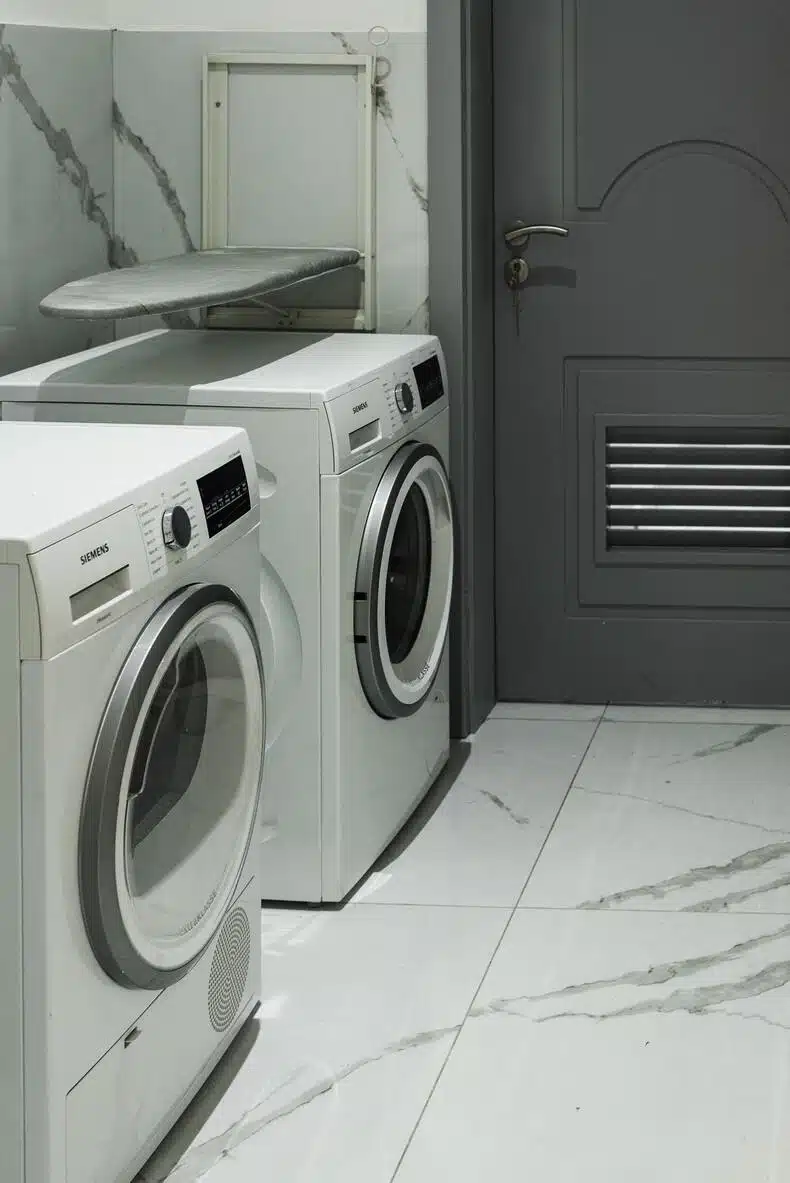 A small laundry room with vinyl flooring, showcasing a variety of patterns and colors.