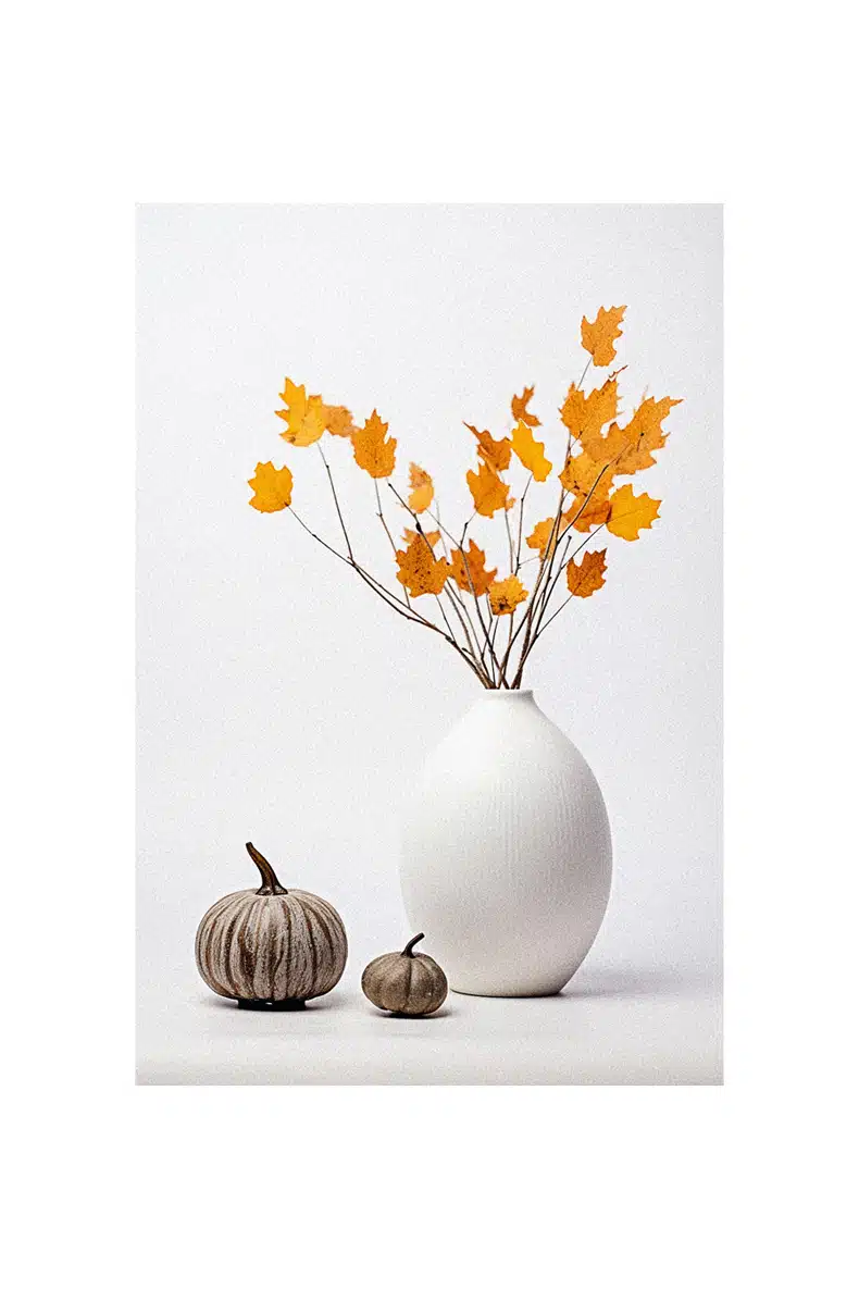 Autumn decorating ideas: A white vase with orange leaves.