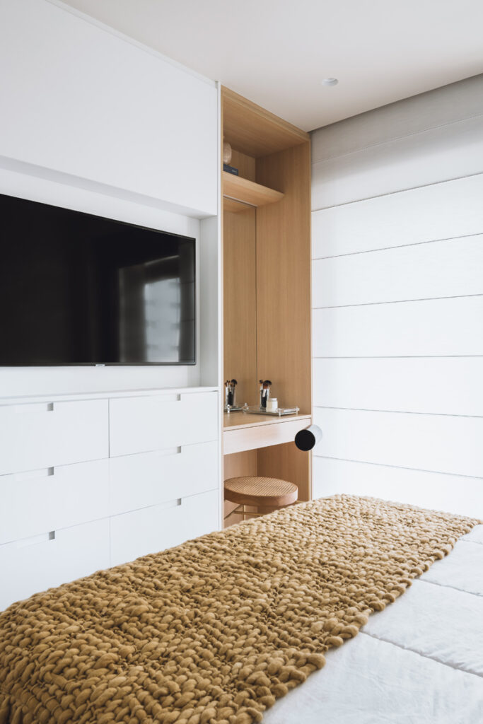 A bed in a bedroom with a tv.