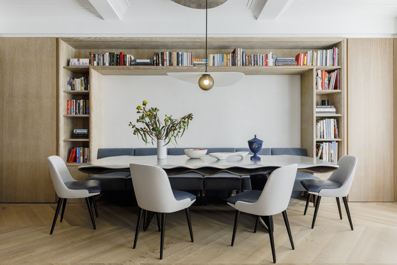 A dining room with bookshelves and a table.