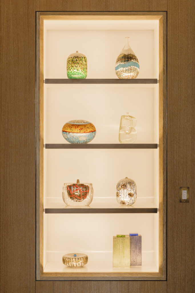 A wooden shelf with a lot of vases on it.