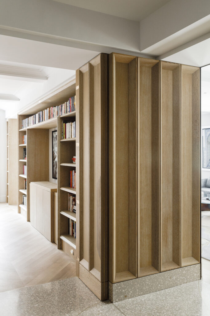 A hallway with bookshelves and a bookcase.