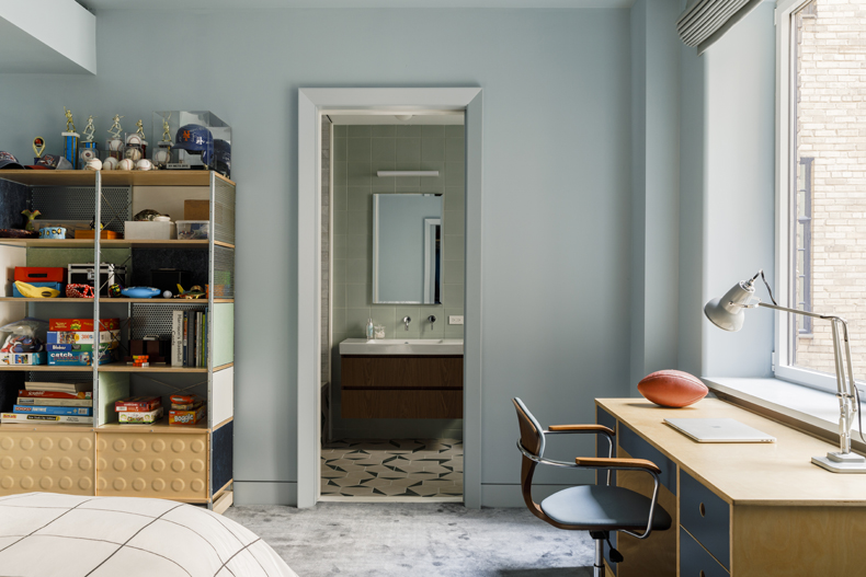 A bedroom with blue walls and a desk.