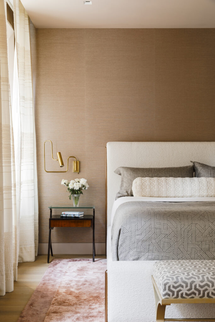 A bed in a bedroom with beige walls.