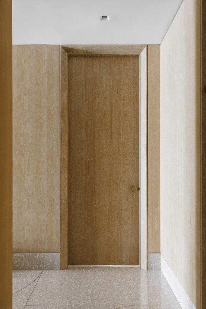 An empty hallway with a wooden door.