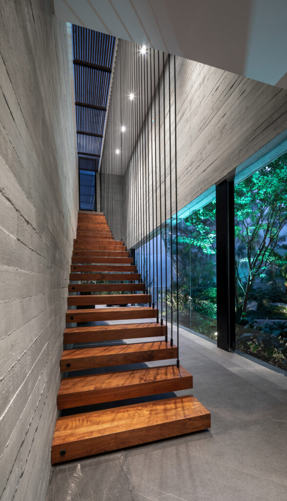 A modern staircase with a glass wall and wooden steps.