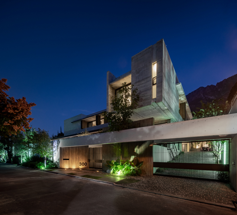 A modern house in the mountains at night.