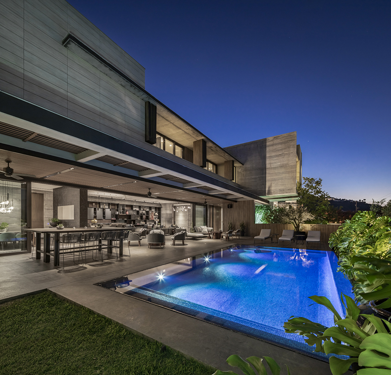A modern house with a swimming pool at night.