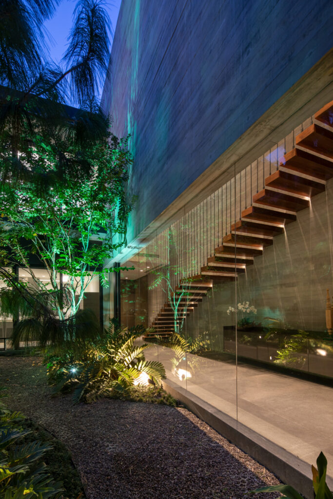 A modern house at night with a green staircase.