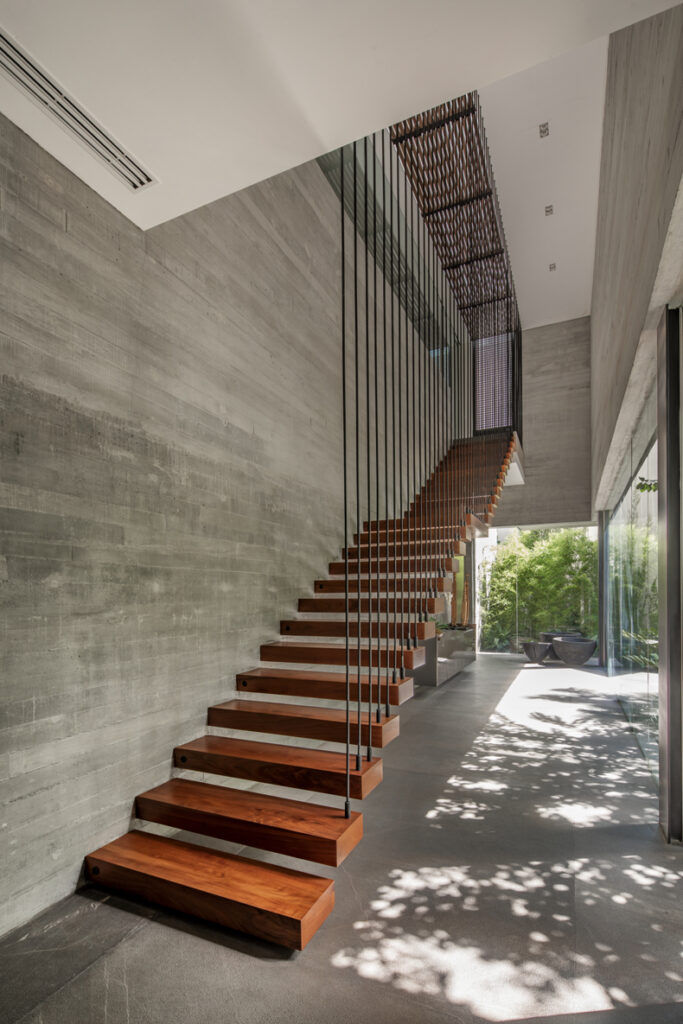 A modern house with wooden stairs and concrete walls.