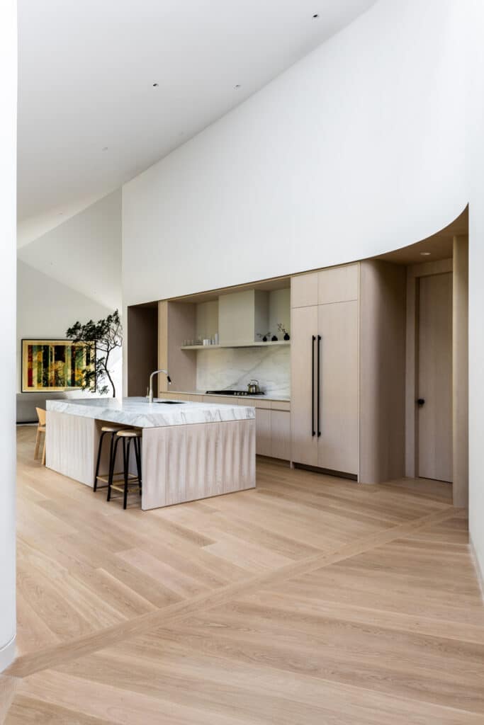 A modern kitchen with wooden floors and a large island.
