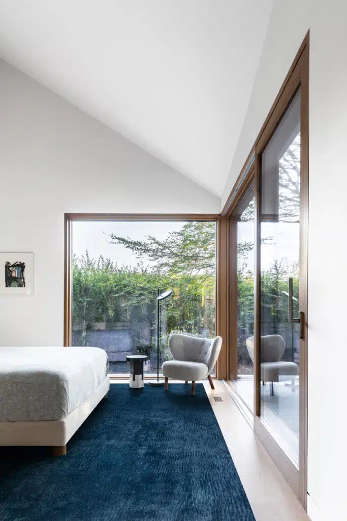 A modern bedroom with a large bed and a blue rug.