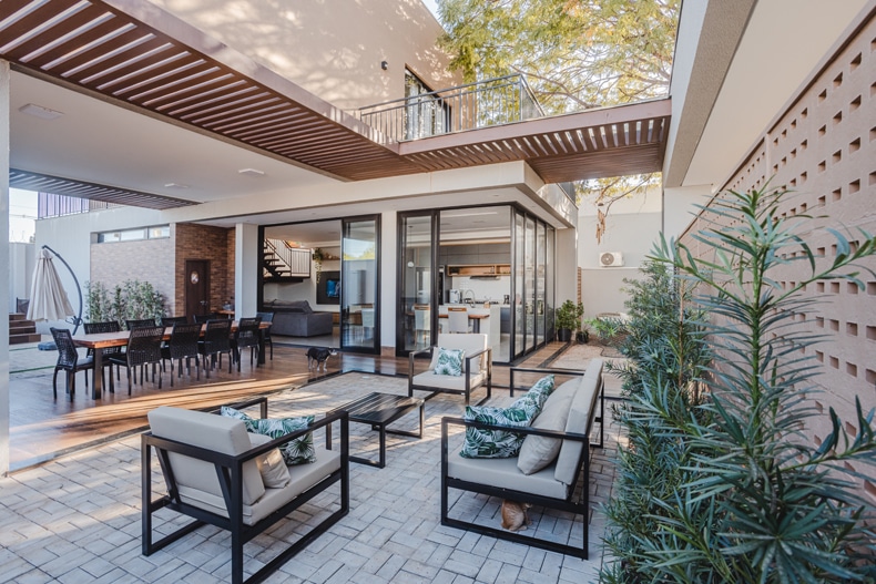A modern house with a patio and outdoor furniture.