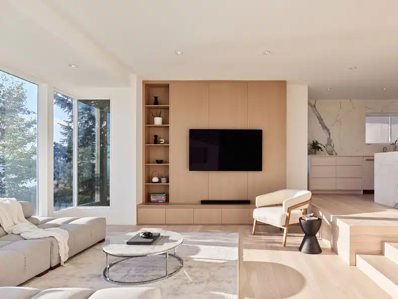 A modern living room with wooden floors and a tv, introducing Rockridge House by BLA Design Group.