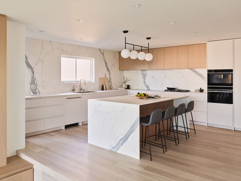 A modern kitchen with marble counter tops and wooden cabinets, fashioned by BLA Design Group.