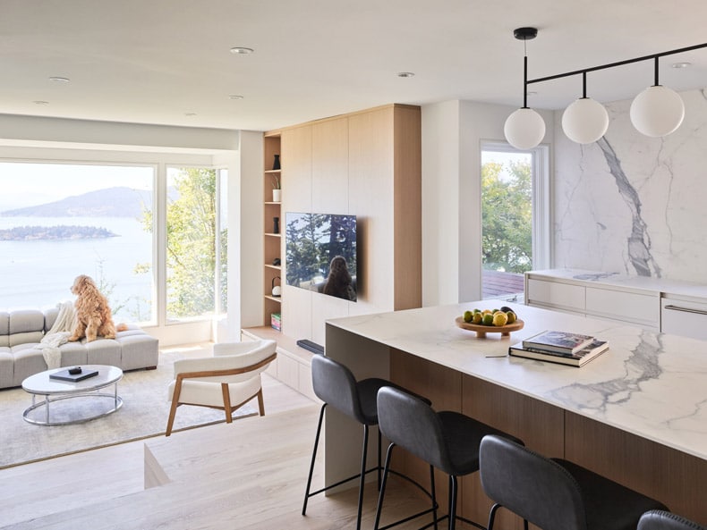 A modern kitchen with marble counter tops and a view of the ocean, fashioned by BLA Design Group.