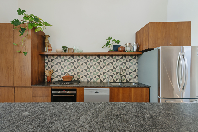 A kitchen with a refrigerator and a sink.