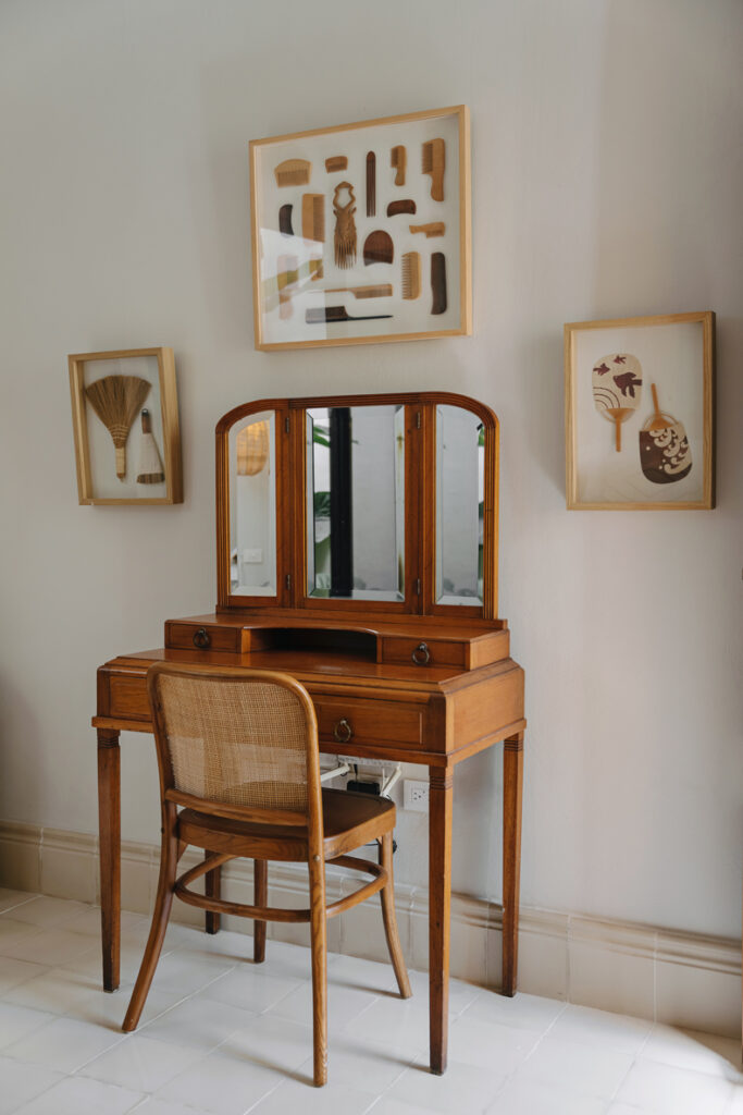 A wooden dressing table with a mirror and a chair.