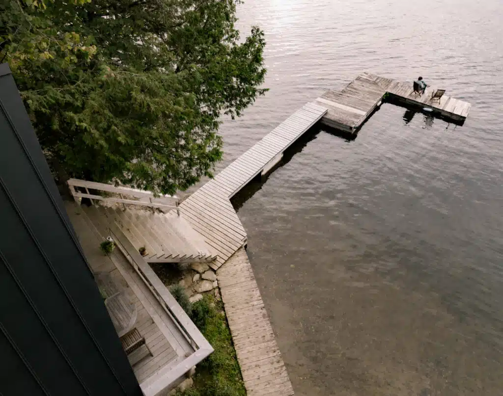 An aerial view of a dock on a lake captured by Matiere Premiere Architecture.