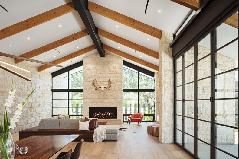 A living room with wood beams and a fireplace.