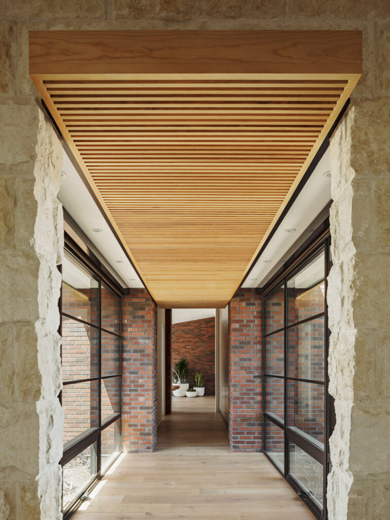 A hallway with a wooden ceiling and glass doors.