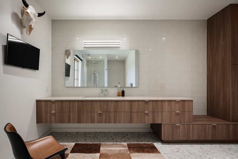 A bathroom with wooden cabinets and a cowhide rug.
