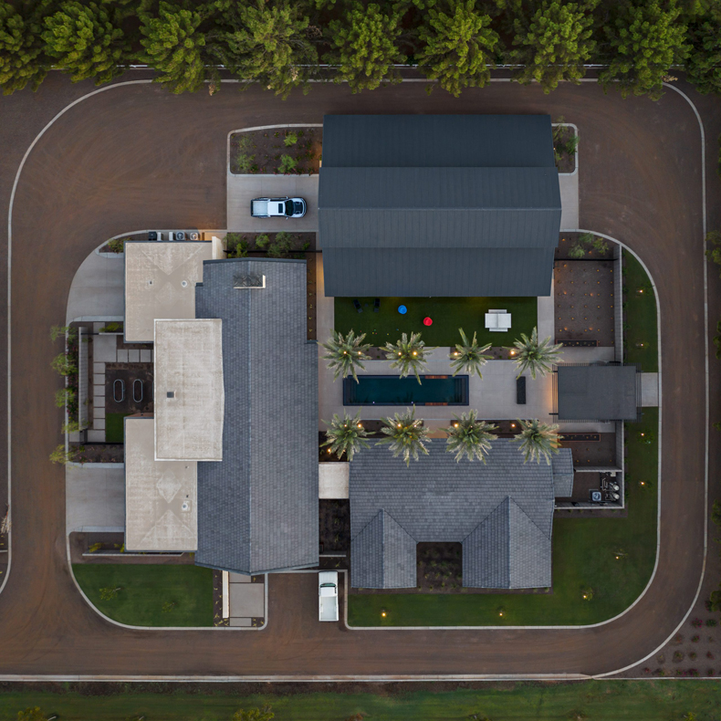 An aerial view of a house with a car parked in the driveway.