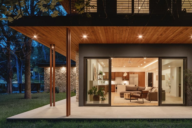 A modern house with wood siding and glass doors.
