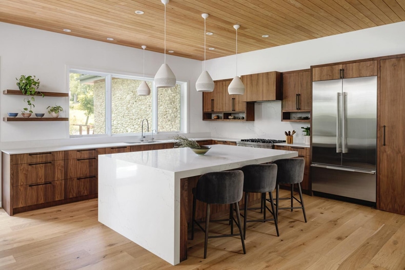 A modern kitchen with wood cabinets and a center island.