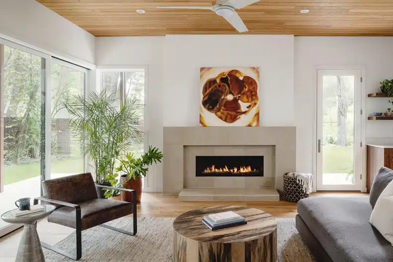 A living room with a wood ceiling and a fireplace.