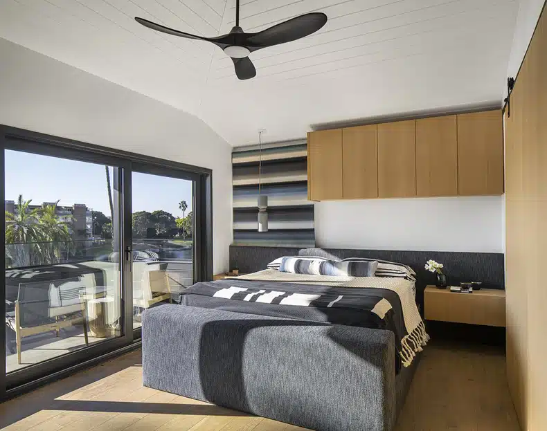 A bedroom with a bed and a fan.