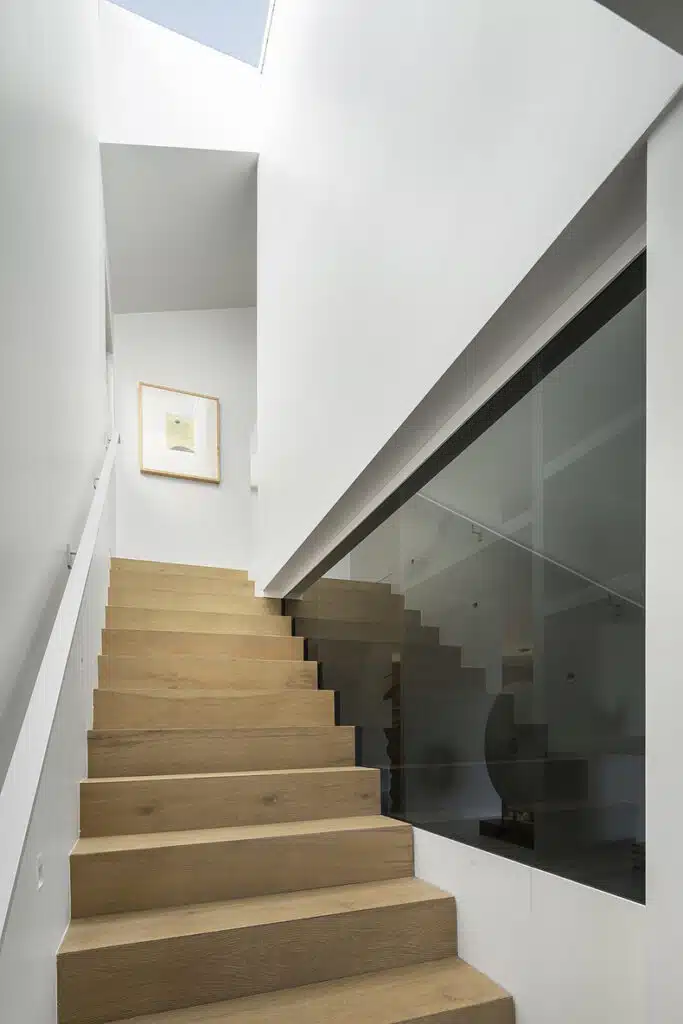 A staircase leading up to a room with a skylight.