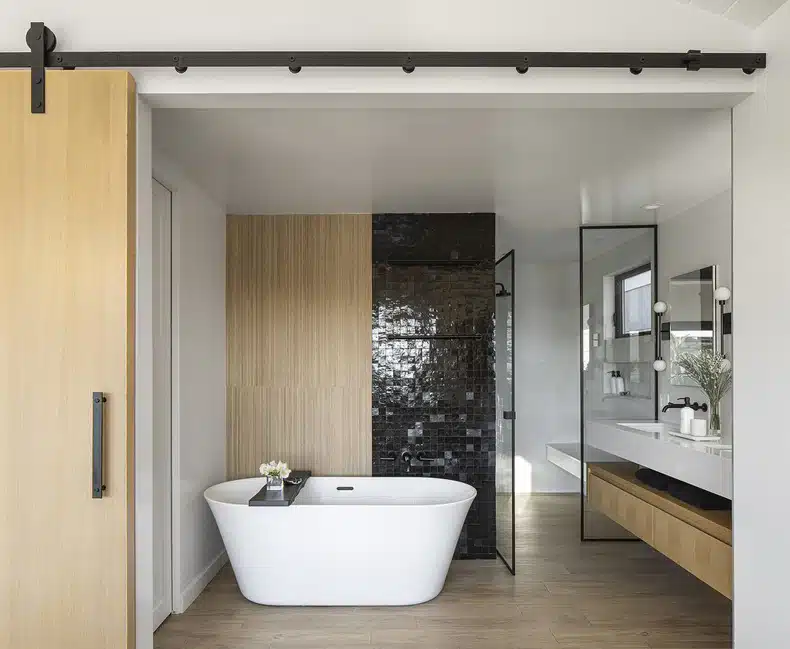A modern bathroom with wooden floors and a bathtub.