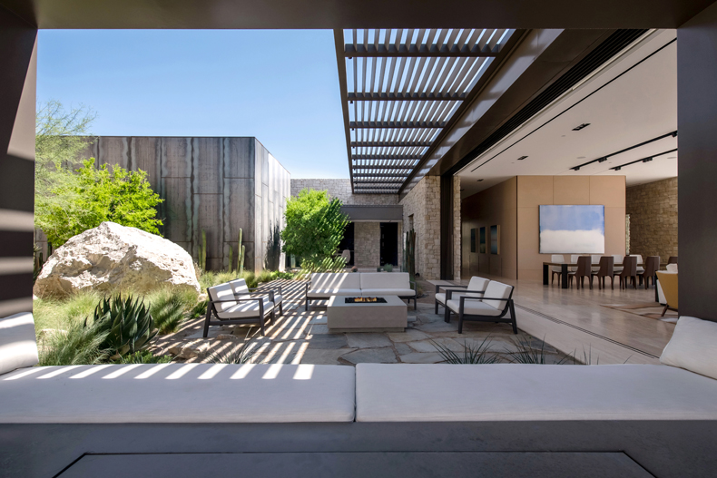 A modern home with a large patio and outdoor furniture.