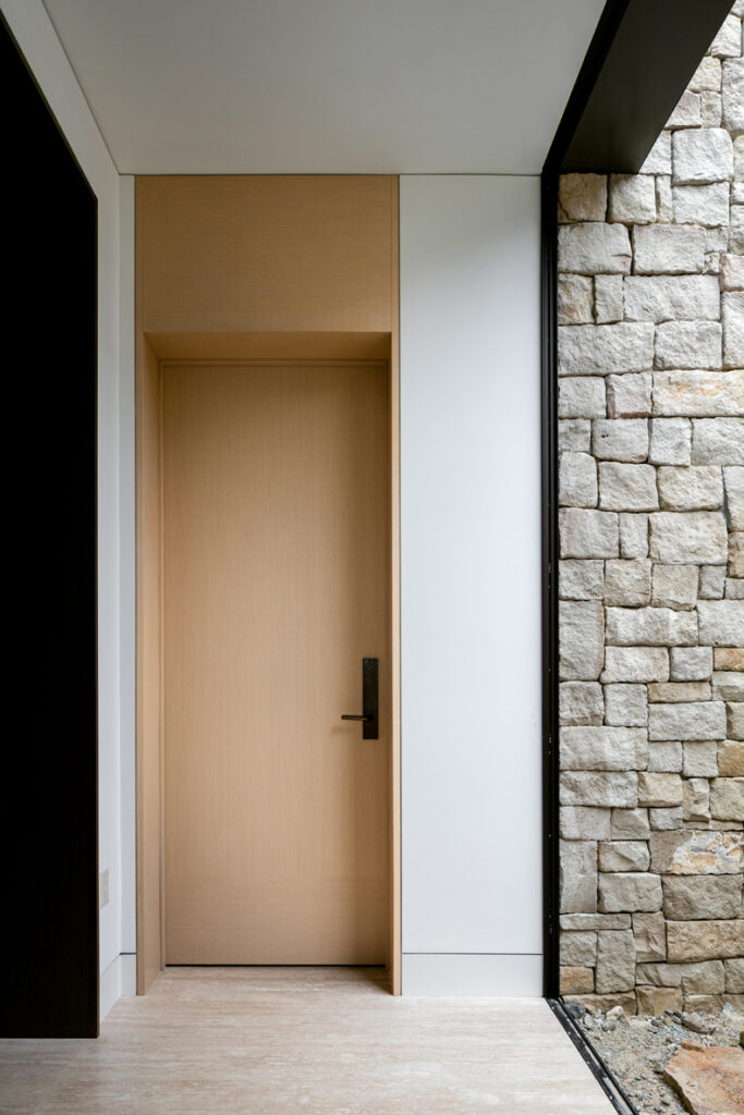 An entryway with a stone wall and wooden door.