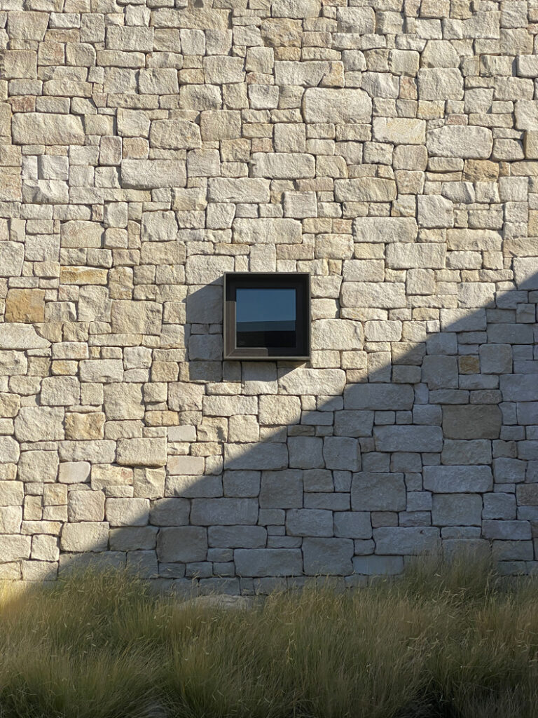 A stone wall with a window on it.