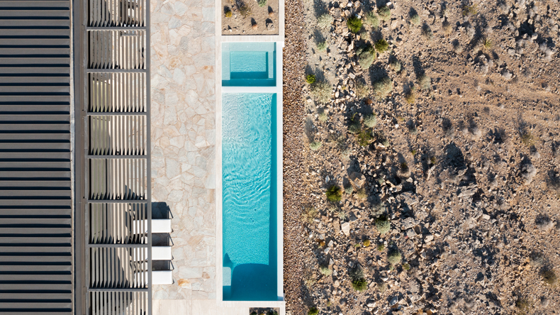An aerial view of a swimming pool in the desert.
