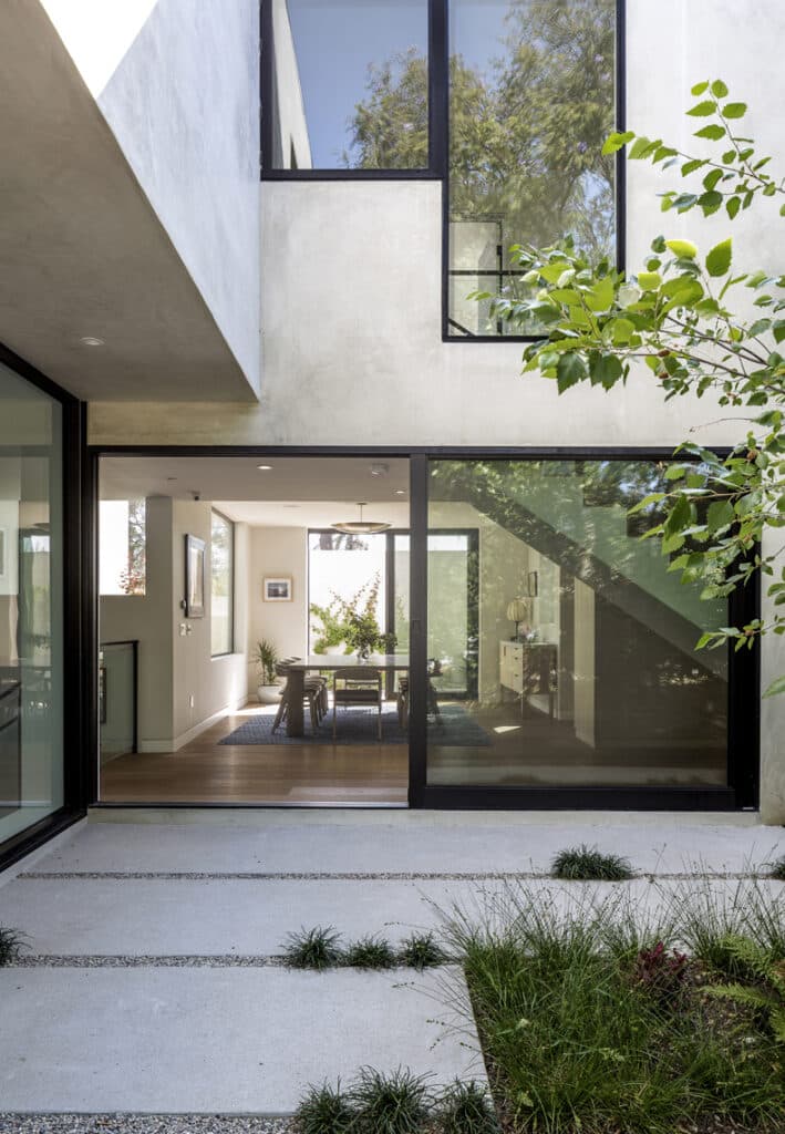 A modern house with glass doors and a patio.