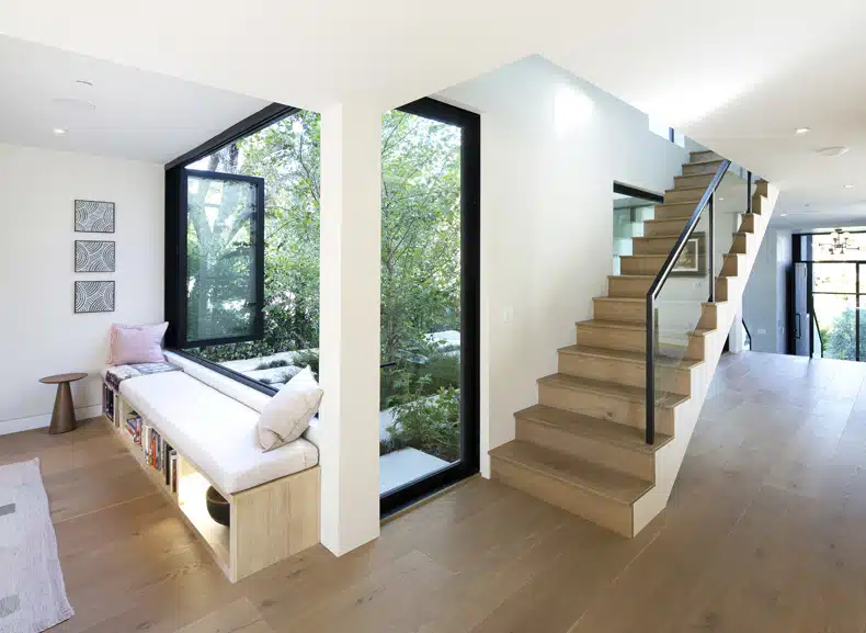 A living room with a large window and stairs.