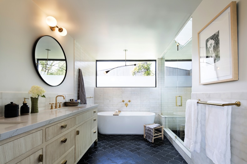A black and white bathroom with a tub and sink.