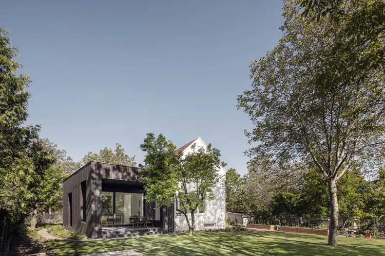 A modern house surrounded by trees and grass.