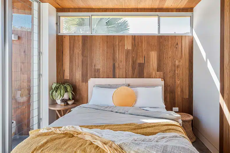 A bedroom with wooden walls and a wooden bed.