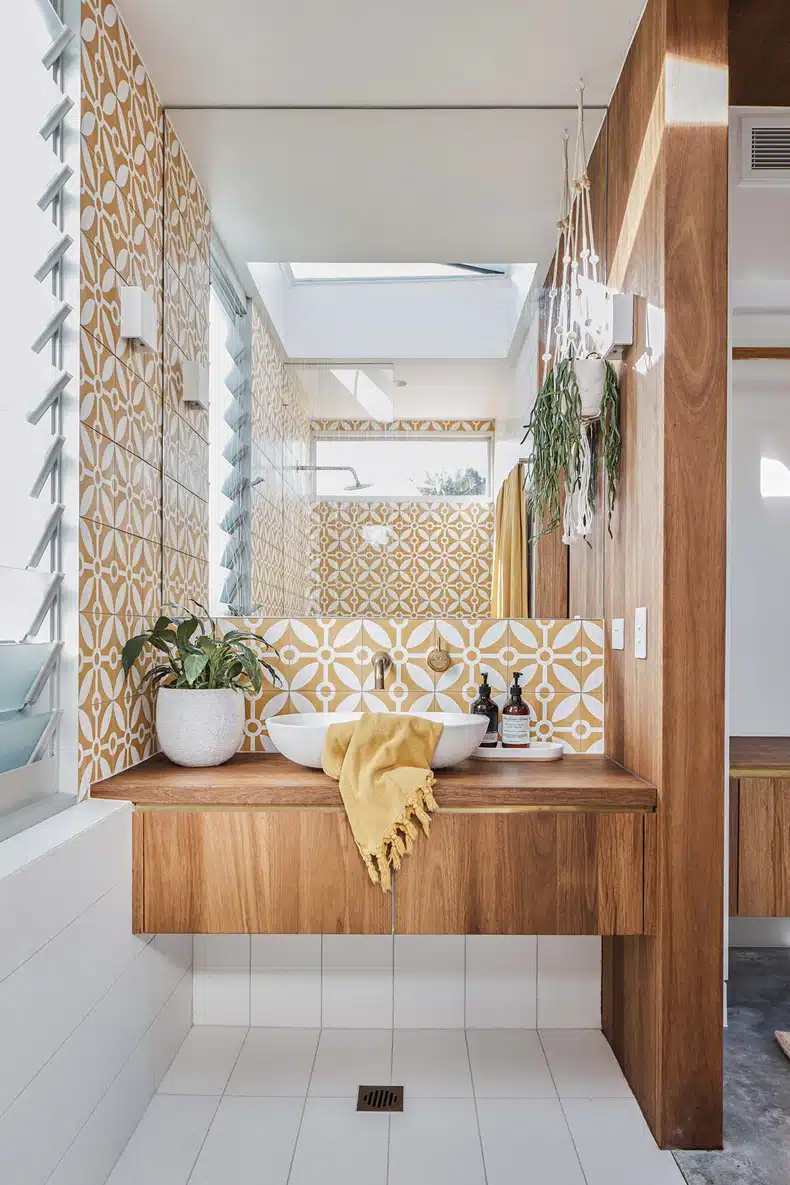 A bathroom with a yellow and white tiled wall.