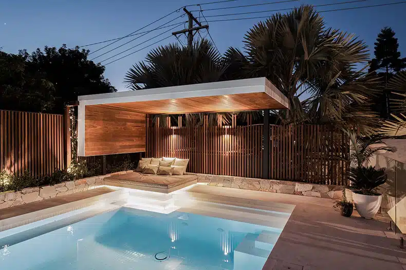 A modern backyard with a swimming pool and a wooden deck.