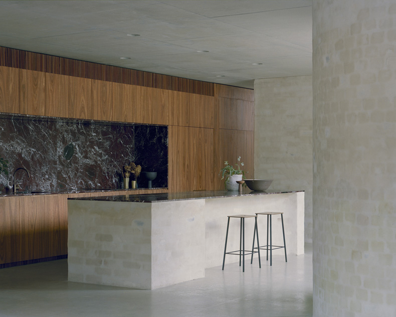 Mary Street House By Edition Office featuring a kitchen with marble counter tops and stools.