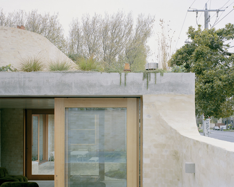 Mary Street House features a concrete wall and a glass door.