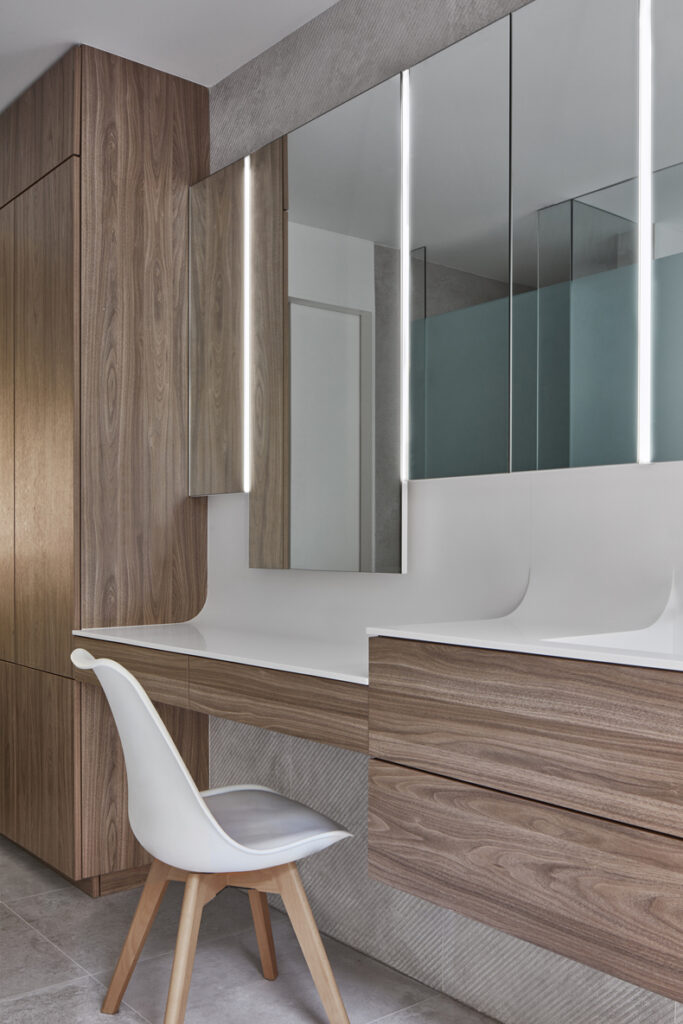 Murray Brown House by Creative Union Network features a modern bathroom with wooden cabinets and mirrors.